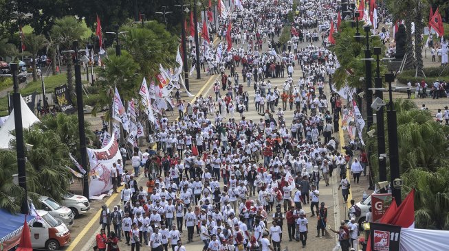 Pendukung pasangan Capres dan Cawapres nomor urut 01, Joko Widodo (Jokowi)-Ma'ruf Amin berjalan menuju lokasi Konser Putih Bersatu dalam rangka kampanye akbar pasangan pasangan tersebut di Gelora Bung Karno (GBK), Jakarta, Sabtu (13/4). [ANTARA FOTO/Nova Wahyudi]