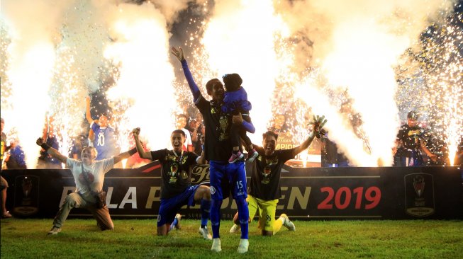 Pemain Arema FC mengangkat tangan merayakan gelar juara Piala Presiden 2019 di Stadion Kanjuruhan Malang, Jawa Timur, Jumat (12/4). [ANTARA FOTO/Budi Candra Setya]