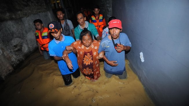 Warga dan petugas BPBD mengevakuasi warga lanjut usia yang rumahnya terdampak banjir di Kabupaten Pamekasan, Jawa Timur, Sabtu (13/4). ANTARA FOTO/Saiful Bahri