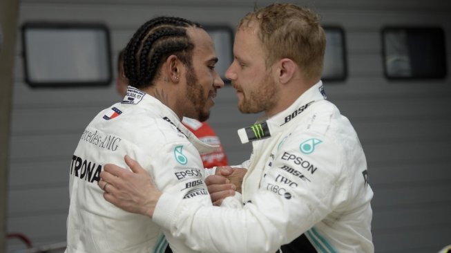 Driver asal Britania Raya, Lewis Hamilton (kiri) merayakan kemenangan tim bersama sang mitra, Valtteri Bottas dari Finlandia di F1 GP China 2019 [AFP/Wang Zhao].
