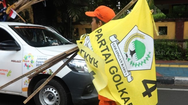 Sejumlah petugas PPSU menurunkan Alat Peraga Kampanye (APK) peserta Pemilu di Kawasan Imam Bonjol, Jakarta, Minggu (14/4). [Suara.com/Muhaimin A Untung]