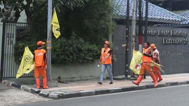 Sejumlah petugas PPSU menurunkan Alat Peraga Kampanye (APK) peserta Pemilu di Kawasan Imam Bonjol, Jakarta, Minggu (14/4). [Suara.com/Muhaimin A Untung]