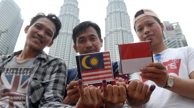 WNI di Malaysia menunjukkan jari yang telah dicelup tinta usai menggunakan hak suaranya di Kuala Lumpur City Center (KLCC) seusai mencoblos di KBRI di KLCC, Malaysia, Minggu (14/4). ANTARA FOTO/Rafiuddin Abdul Rahman