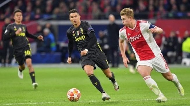 Bintang Juventus Cristiano Ronaldo (tengah) mengejar bola dibayangi oleh bek Ajax Matthijs de Ligt saat laga Liga Champions di Johan Cruijff ArenA. EMMANUEL DUNAND / AFP