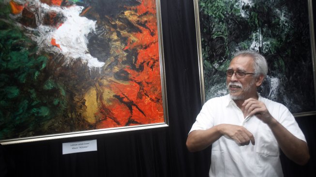 Penyanyi dan pencipta lagu Iwan Fals menjelaskan sejumlah lukisan hasil karyanya saat pembukaan pameran di Galeri Suara Hati, Depok, Jawa Barat, Senin (15/4). [FOTO/Yulius Satria Wijaya]
