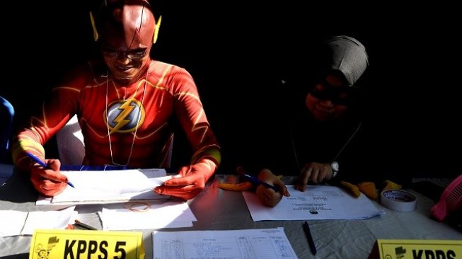 Petugas KPPS melayani warga yang akan memberikan hak suaranya di TPS 5 Pondok Benowo Indah yang bertema super hero di Surabaya, Jawa Timur, Rabu (17/4/2019). [ANTARA FOTO/Zabur Karuru].