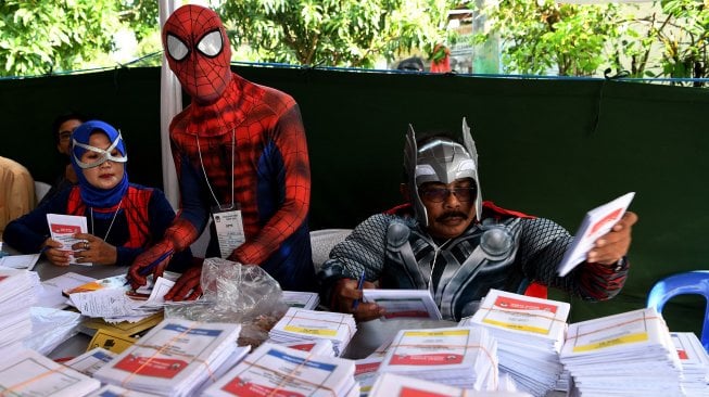 Petugas KPPS berkostum superhero Avengers melayani warga saat akan memberikan hak suaranya di TPS 5 Pondok Benowo Indah yang bertema super hero di Surabaya, Jawa Timur, Rabu (17/4). [ANTARA FOTO/Zabur Karuru]
