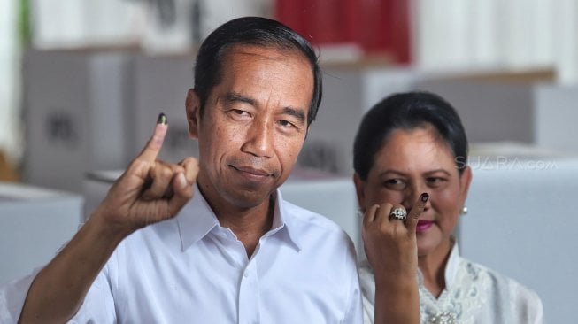 Calon Presiden nomor urut 01 Joko Widodo bersama Istrinya Iriana Joko Widodo menggunakan hak suaranya di TPS, Jakarta Pusat, Rabu (17/4). [Suara.com/Muhaimin A Untung]