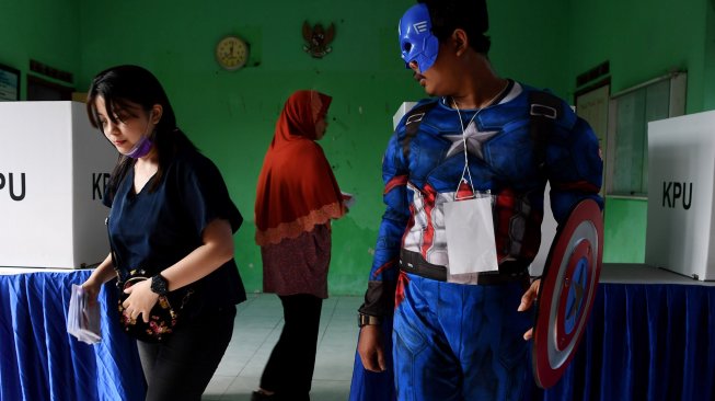 Petugas KPPS berkostum superhero Avengers melayani warga saat akan memberikan hak suaranya di TPS 5 Pondok Benowo Indah yang bertema super hero di Surabaya, Jawa Timur, Rabu (17/4). [ANTARA FOTO/Zabur Karuru]
