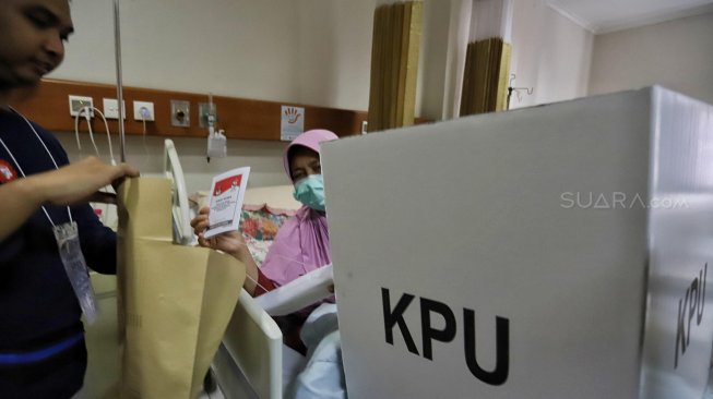 Seorang pasien menggunakan hak pilihnya di TPS 034, RSCM, Rabu (17/4). [Suara.com/Muhaimin A Untung]
