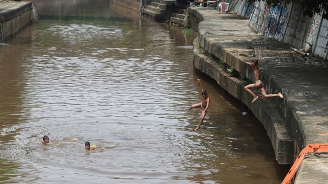 Sejumlah anak bermain di Sungai Ciliwung, Jakarta, Kamis (18/4). [Suara.com/Muhaimin A Untung]