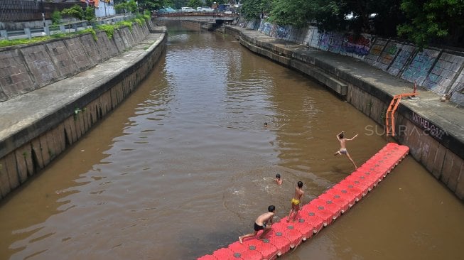 Sejumlah anak bermain di Sungai Ciliwung, Jakarta, Kamis (18/4). [Suara.com/Muhaimin A Untung]