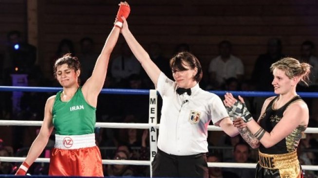 Petinju Putri Iran Sadaf Khadem (kiri) memenangkan pertarungan atas petinju Perancis Anne Chauvin dalam duel di Royan, Prancis, Sabtu (13/4/2019). [AFP/Mehdi Fedouach]