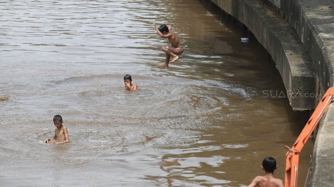 Sejumlah anak bermain di Sungai Ciliwung, Jakarta, Kamis (18/4). [Suara.com/Muhaimin A Untung]