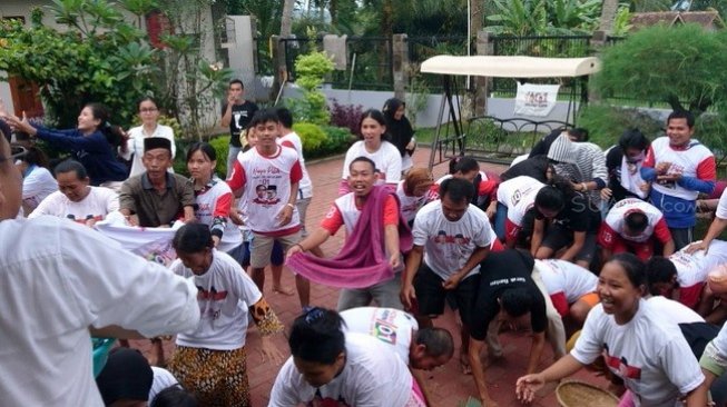 Sejumlah warga Kampung Kadaung, Serang, Banten berebut uang logam hasil saweran sebagai wujud rasa syukur atas kemenangan paslon 01, Jokowi - Ma'ruf Amin, berdasarkan hasil quick count sejumlah lembaga survei, Jumat (19/4/2019). [Suara.com/Yandhi Deslatama]