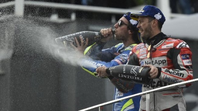 Pebalap Ducati, Andrea Dovizioso (kanan) merayakan keberhasilannya memenangi MotoGP Valencia bersama Alex Rins (Suzuki) yang finis kedua, Minggu (18/11/2018). [AFP/Jose Jordan]