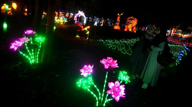 Pengunjung menikmati wisata keindahan Pesona Taman Lampion, di Taman Dadaha, Kota Tasikmalaya, Jawa Barat, Jumat (19/4).[ANTARA FOTO/Adeng Bustomi]
