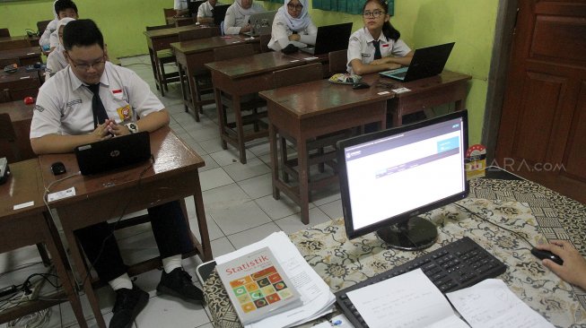 Pelajar mengikuti Ujian Nasional Berbasis Komputer (UNBK) di SMPN 85 Jakarta, Jakarta Selatan, Senin (22/4).[Suara.com/Arief Hermawan P]