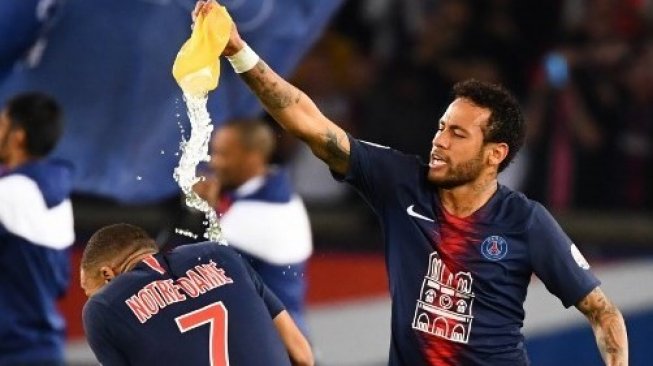 Bintang Paris Saint-Germain, Neymar (kanan) melempari kantong kepada Kylian Mbappe saat merayakan juara Liga Prancis di Parc des Princes Stadium. FRANCK FIFE / AFP