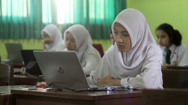 Pelajar mengikuti Ujian Nasional Berbasis Komputer (UNBK) di SMPN 85 Jakarta, Jakarta Selatan, Senin (22/4). [Suara.com/Arief Hermawan P]