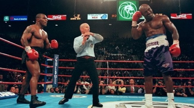 Wasit Lane Mills (tengah) menghentikan pertarungan setelah Mike Tyson (kiri) menggigit telinga kanan Evander Holyfield dalam pertarungan di MGM Grand Garden Arena, Las Vegas, AS, Sabtu (28/6/1997). [AFP/Jeff Haynes]