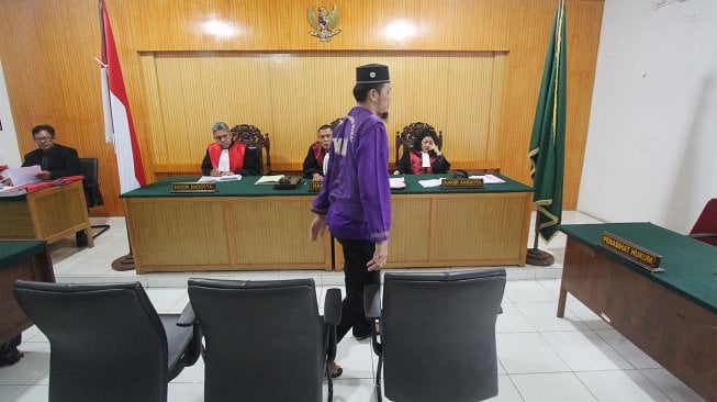 Terdakwa kasus tindak pidana narkotika Kaharuddin alias Achong berdiri usai menjalani sidang vonis di Pengadilan Negeri Dumai di Dumai, Riau, Selasa (23/4). [ANTARA FOTO/Aswaddy Hamid]