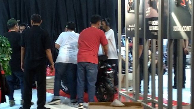 Sejumlah pekerja sedang memindahkan sebuah sepeda motor yang diduga sebagai Honda X-ADV di JIExpo, Kemayoran, Jakarta Pusat, Rabu (24/4/2019) jelang pembukaan IIMS 2019. [Suara.com/Manuel Jeghesta Nainggolan] 