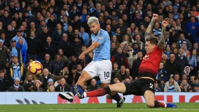 Pemain Manchester City Sergio Aguero (kiri) berebut bola dengan pemain Manchester United John Stones dalam laga derby yang berlangsung di Etihad Stadium pada 11 November 2018 [AFP]