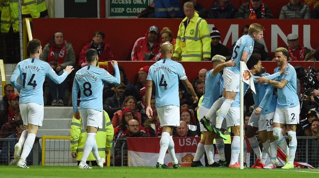 Para pemain Manchester City merayakan gol selama pertandingan sepak bola Liga Premier Inggris antara Manchester United melawan Manchester City di Old Trafford, Manchester, Inggris, Kamis (25/4) dini hari WIB. [Oli SCARFF / AFP]