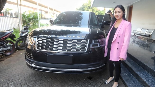 Artis Nagita Slavina bersama mobilnya Range Rover berpose saat berkunjung di kantor Redaksi Suara.com, Jakarta, Kamis (25/4). [Suara.com/Muhaimin A Untung]