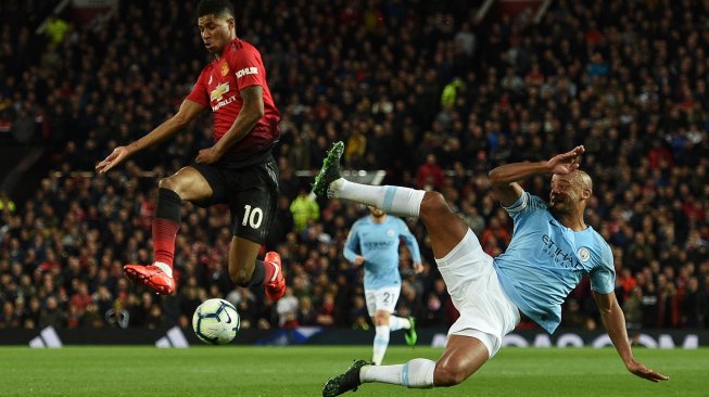 Bek Manchester City Vincent Kompany bersaing dengan pemain depan Manchester United Marcus Rashford selama pertandingan sepak bola Liga Premier Inggris antara Manchester United melawan Manchester City di Old Trafford, Manchester, Inggris, Kamis (25/4) dini hari WIB. [Oli SCARFF / AFP]