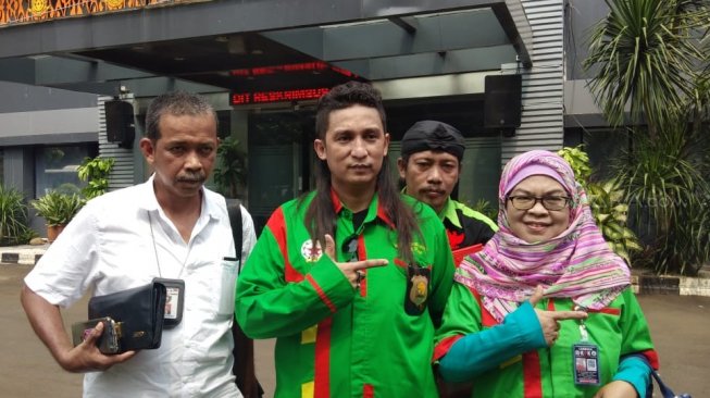 Pelapor akun Instagram @erintaulany, Firdaus Oiwobo, di Polda Metro Jaya, Jumat (26/4/2019). [Suci Febriastuti/Suara.com]