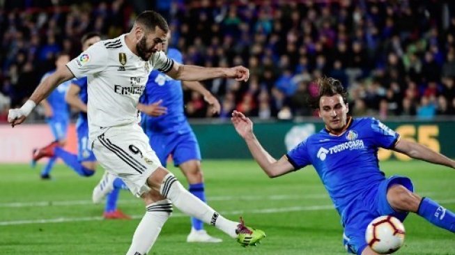 Tendangan sriker Real Madrid Karim Benzema (kiri) diblok bek Getafe Ignasi Miquel dalam lanjutan Liga Spanyol. JAVIER SORIANO / AFP