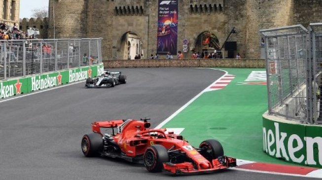 Pebalap andalan Ferrari, Sebastian Vettel (kanan), berada di depan rivalnya dari tim Mercedes, Lewis Hamilton, pada balapan F1 GP Azerbaijan di Sirkuit Baku, Minggu (29/4/2018). [AFP/Kirill Kudryavtsev]