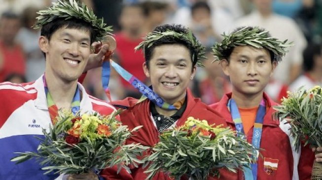 Legenda bulutangkis Indonesia, Taufik Hidayat (tengah), merayakan keberhasilan meraih medali emas Olimpiade 2004 Athena, Yunani. [AFP/