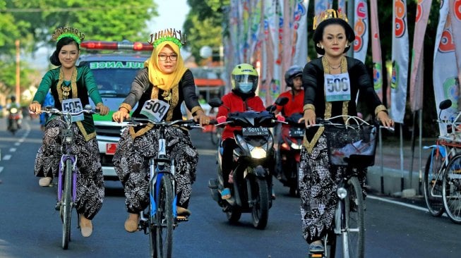 Peserta dengan busana kebaya mengayuh sepeda pada Banyuwangi Woman Cycling Challenge di Banyuwangi, Jawa Timur, Sabtu (27/4).  [ANTARA FOTO/Budi Candra Setya]