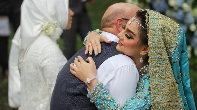 Irish Bella sungkeman bersama orang tua saat acara akad nikah di Bandung, Jawa Barat, Minggu (28/4). [Suara.com/Muhaimin A Untung]