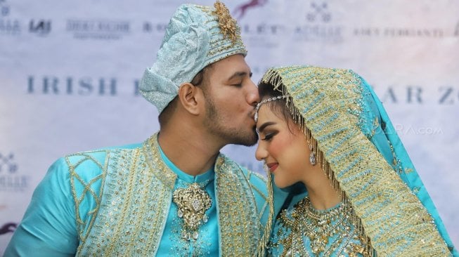 Ammar Zoni saat mencium kening Irish Bella usai akad nikah di Bandung, Jawa Barat, Minggu (28/4). [Suara.com/Muhaimin A Untung]