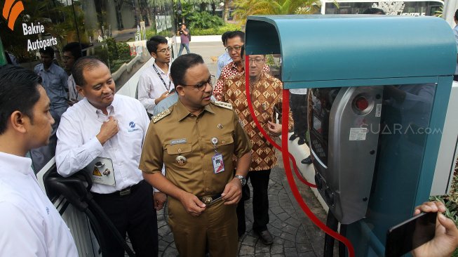 Gubernur DKI Jakarta Anies Baswedan (kiri) didampingi Direktur PT Transjakarta Agung Wicaksono (kanan) menjajal bus listrik di kawasan Monas, Jakarta Pusat, Senin (29/4). [Suara.com/Arief Hermawan P]