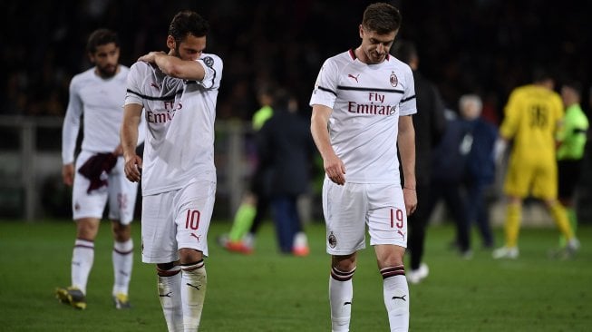 Pemain tengah AC Milan Hakan Chalhanoglu dan penyerang AC Milan asal Krzysztof Piatek tertunduk lemas pada akhir pertandingan sepak bola Serie A Italia antara Torino melawan AC Milan di Stadion Grande Torino, Turin, Italia, Senin (29/4) dini hari WIB. [MARCO BERTORELLO / AFP]