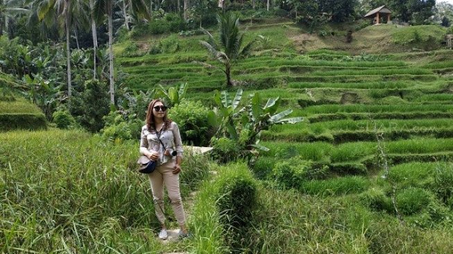 Pengunjuing di tengah hamparan sawah di Tegallalang Rice Terrace, Gianyar, Bali. (Suara.com/Firsta Nodia)