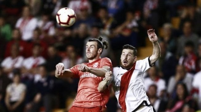 Pemain Real Madrid Gareth Bale berebut bola dengan pemain Rayo Vallecano dalam pertandingan yang berlangsung Senin (29/4/2019) [AFP]