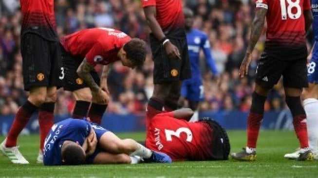 Pemain Manchester United Eric Bailly mengalami cedera usai bertabrakan dengan pemain Chelsea dalam pertandingan Liga Inggris yang berlangsung di Old Trafford, Minggu (28/4/2019) [AFP]