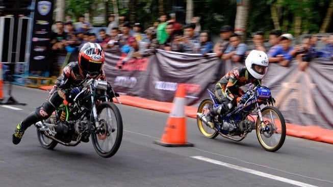 Dua pebalap beradu cepat saat Gadhuro Drag Bike series 2019-201 meter di sirkuit Borobudur, Magelang, Jawa Tengah, Minggu (7/4/2019). Ajang balap motor sepanjang 201 meter tersebut mempertandingkan 16 kelas dan diikuti puluhan pebalap dari berbagai kota di pulau Jawa [ANTARA FOTO/Anis Efizudin/AMA].