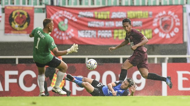 Pesepak bola klub PSM Makassar Rahmat Syamsuddin Leo (kanan) menendang bola yang berhasil ditahan pesepak bola klub Home United FC Hoo Wai Loon (tengah) pada pertandingan fase Grup H Piala AFC 2019 di Stadion Pakansari, Bogor, Jawa Barat, Selasa (30/4/2019). Pada pertandingan tersebut PSM Makassar menang atas klub asal Singapura Home United FC dengan skor 3-2 sehingga PSM Makassar dipastikan lolos ke babak semifinal. ANTARA FOTO/Hafidz Mubarak