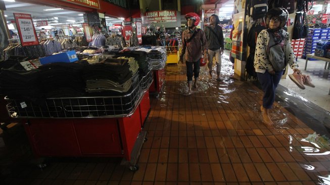 Seorang karyawan menata pakaian di Hi-Tech Mall yang terendam banjir di Surabaya, Jawa Timur, Senin (29/4). [ANTARA FOTO/Moch Asim]