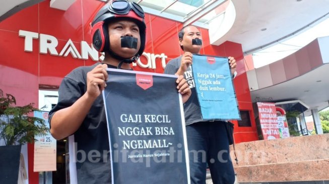 Dua jurnalis menggelar aksi damai saat peringatan May Day di Kediri, Jatim. (beritajatim.com).