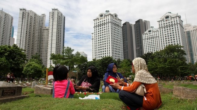 Warga berziarah kubur di Tempat Pemakaman Umum Karet Tengsin, Jakarta, Rabu (1/5). [Suara.com/Arief Hermawan P]
