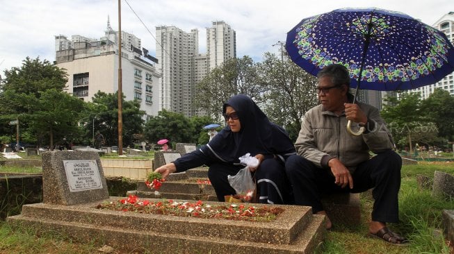 Warga berziarah kubur di Tempat Pemakaman Umum Karet Tengsin, Jakarta, Rabu (1/5). [Suara.com/Arief Hermawan P]
