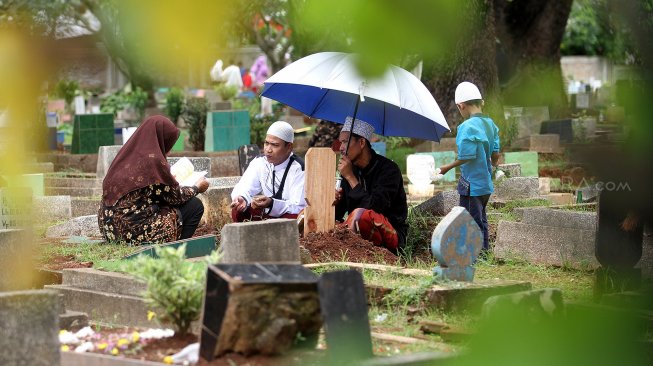 Warga berziarah kubur di Tempat Pemakaman Umum Karet Tengsin, Jakarta, Rabu (1/5). [Suara.com/Arief Hermawan P]
